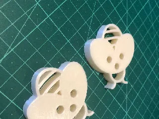 White children's bee buttons for clothing with detailed wings and holes for sewing