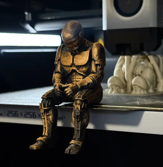 Sad RoboCop figurine sitting on a ledge!
