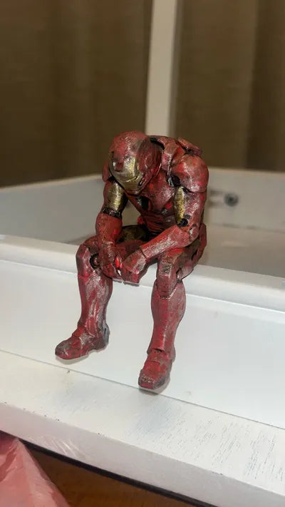 Sad Iron Man Figurine sitting on a ledge!