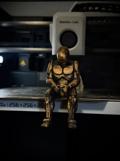 Sad RoboCop figurine sitting on a ledge!